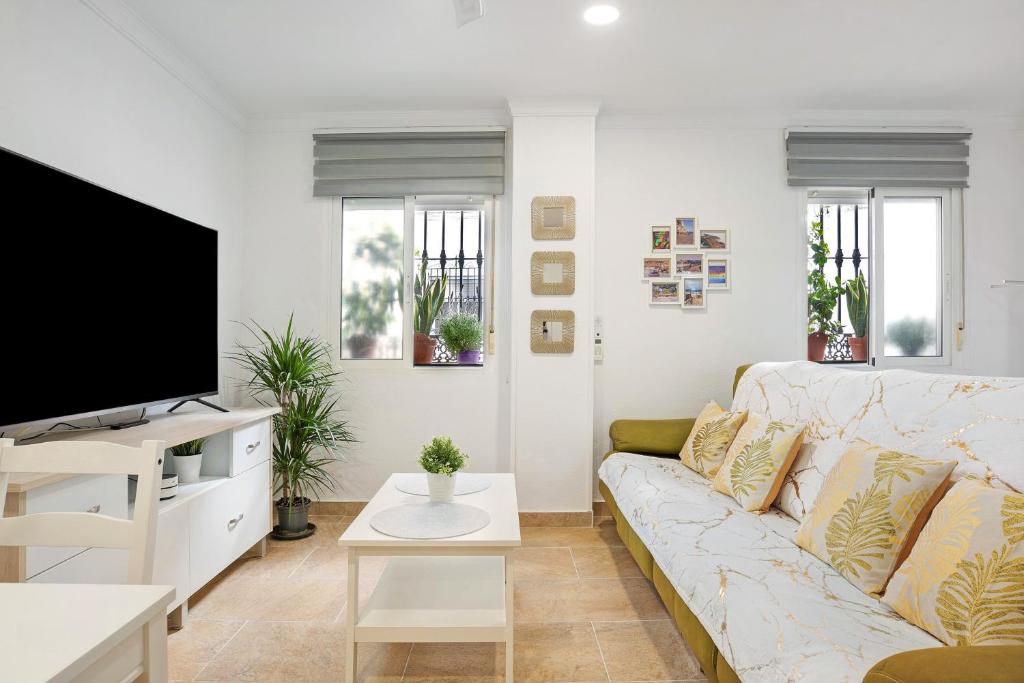uma sala de estar com um sofá e uma televisão de ecrã plano em Loft Centro Historico Barbate em Barbate