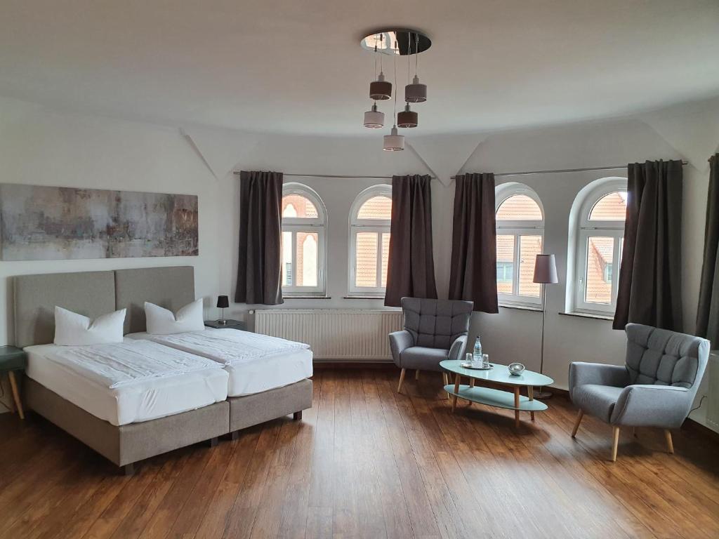 una camera con un letto e due sedie e un tavolo di Hotel Fürstenhof a Rathenow