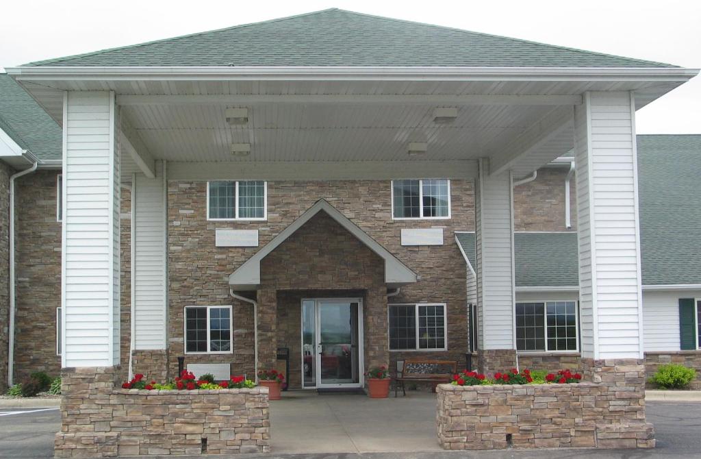 a brick house with a porch with red flowers at Savanna Inn & Suites in Savanna