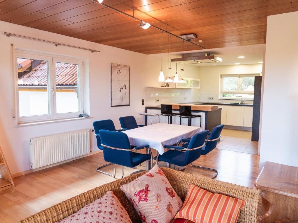 ein Wohnzimmer mit einem Tisch und Stühlen sowie eine Küche in der Unterkunft Apartmenthaus Schöne Aussicht in Bräunlingen