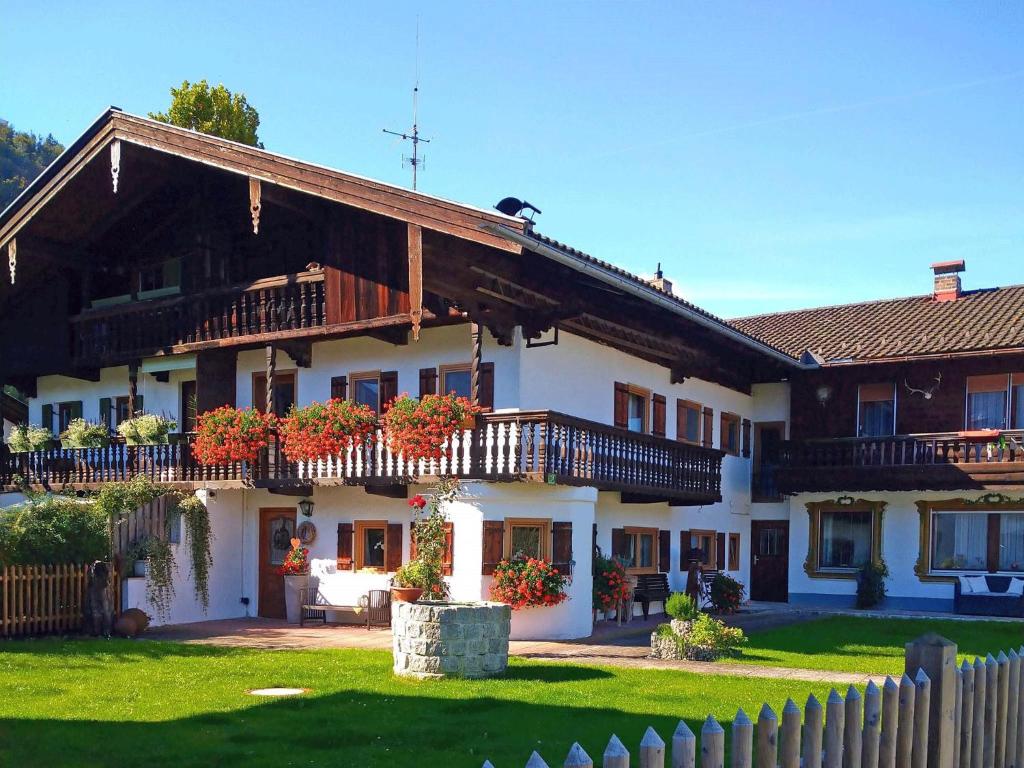ein großes weißes Haus mit Balkonen und einem Zaun in der Unterkunft Ferienwohnung Kohlstatt in Kiefersfelden