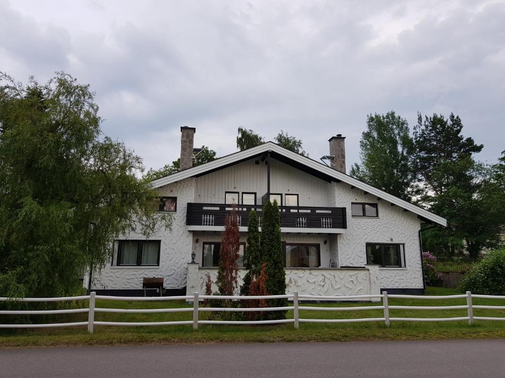 a white house with a fence in front of it at Ekonomirum i Karlstad 