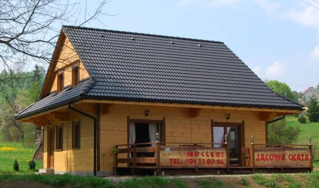 a small wooden house with a black roof at Jacowa Chata in Istebna
