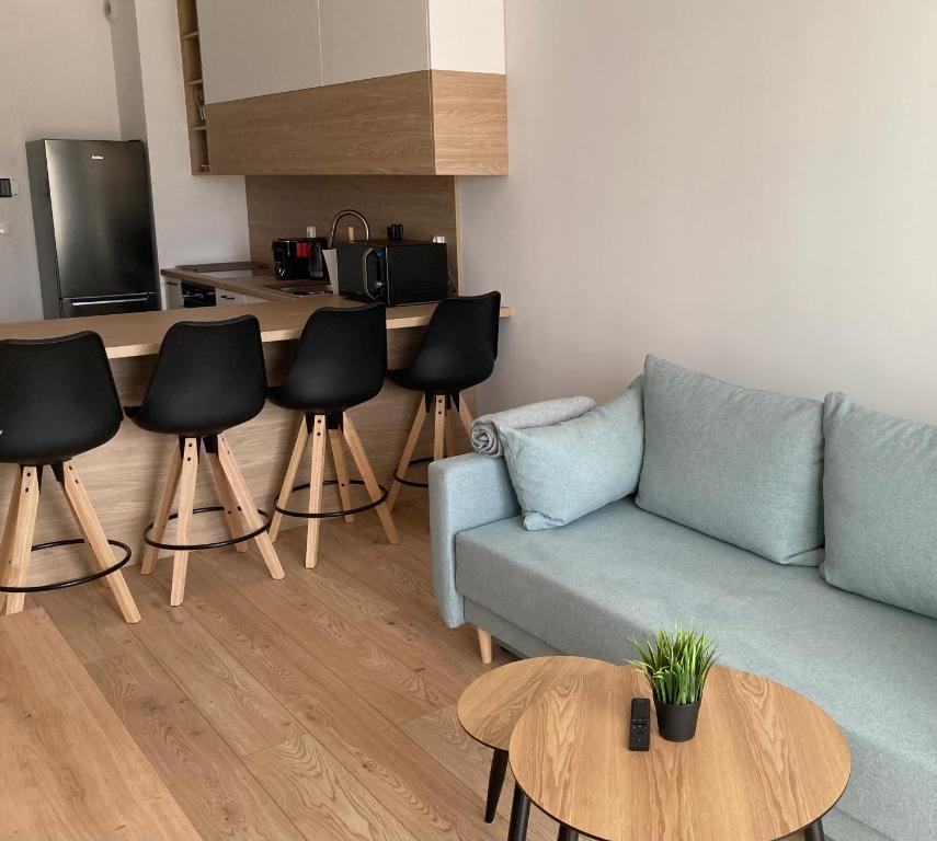 uma sala de estar com um sofá e cadeiras e uma cozinha em Rakowicka Modern Apartment na Cracóvia