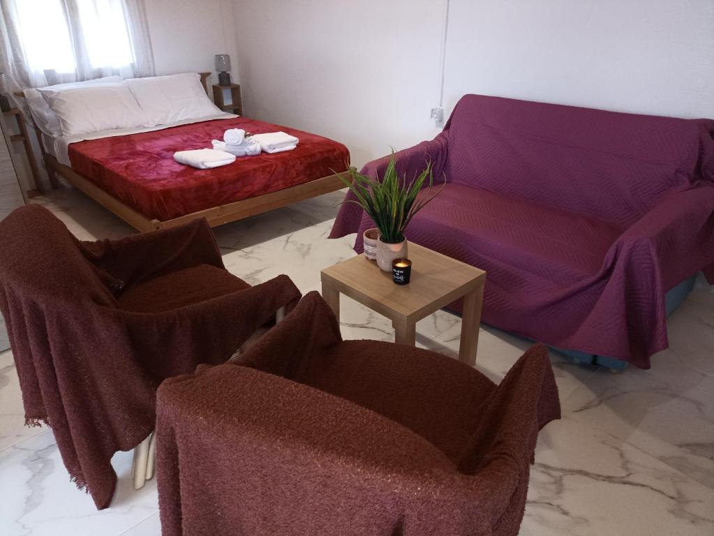 a living room with a couch and two chairs at Chania Mini Villas in Skinés