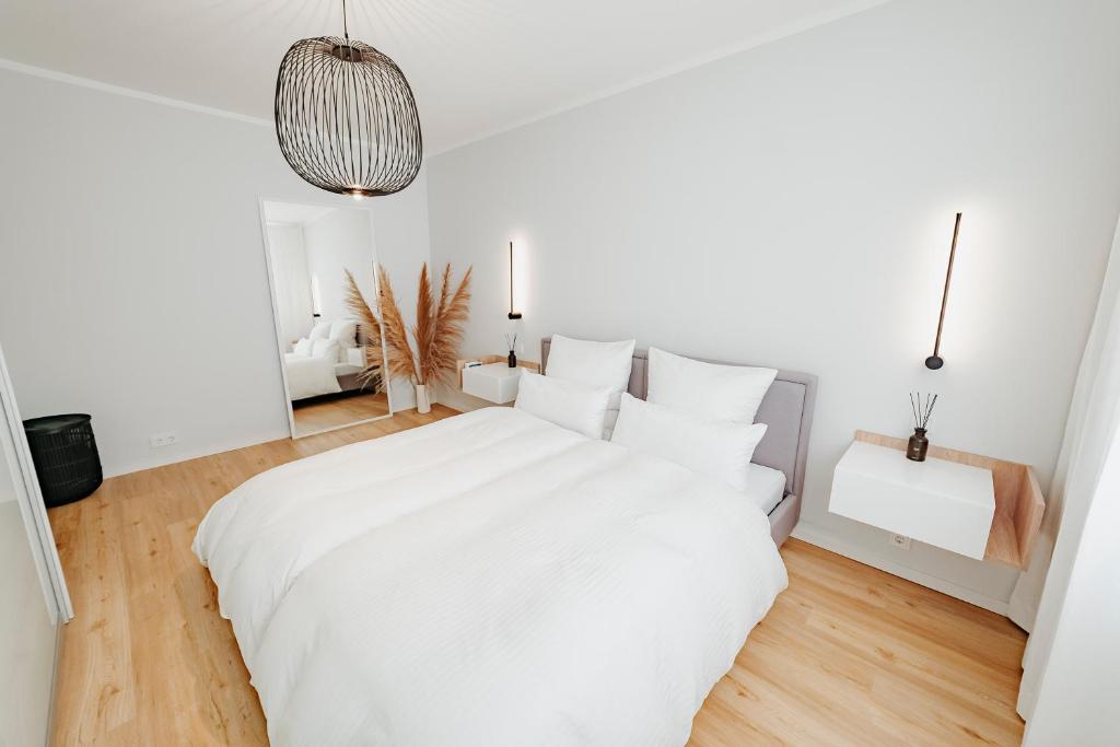 a white bedroom with a large white bed with white pillows at Moderne ruhige 2-Zimmer Wohnung in Coswig in Coswig