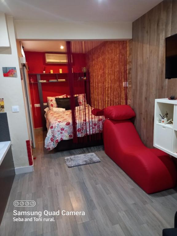 um quarto vermelho com uma cama e uma cadeira vermelha em Loft Hidromasaje Rojo Tantra Ermita San Antonio em Ubrique