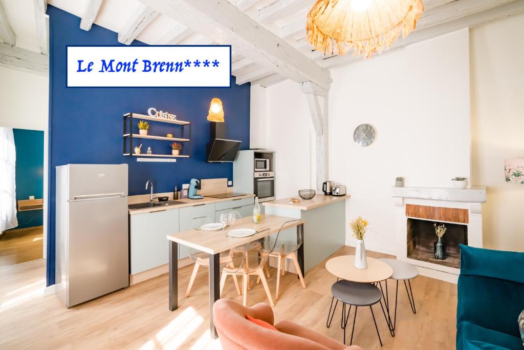 een keuken en een woonkamer met een tafel en stoelen bij Le Mont Brenn in Auxerre