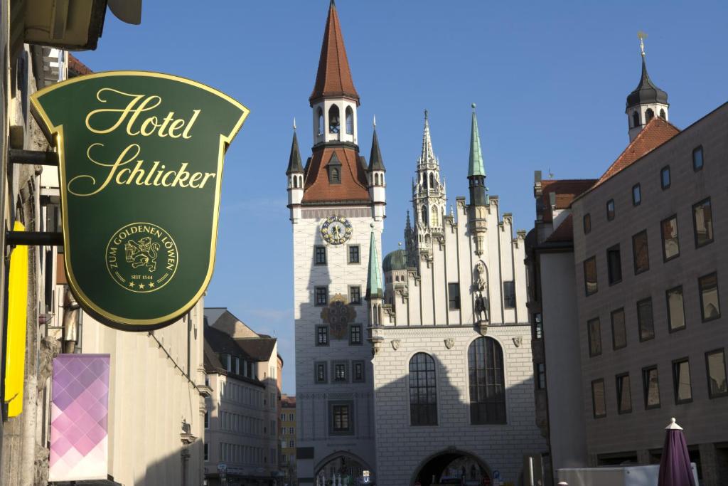 a hotel lighter sign in front of a building with a clock tower at Hotel Schlicker in Munich