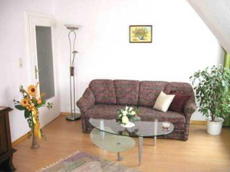 a living room with a couch and a glass table at Ferienwohnung Lioba Kunst in Amorbach