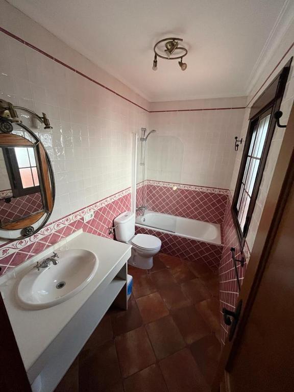 a bathroom with a sink and a toilet and a tub at Casa Kini in Cazalla de la Sierra