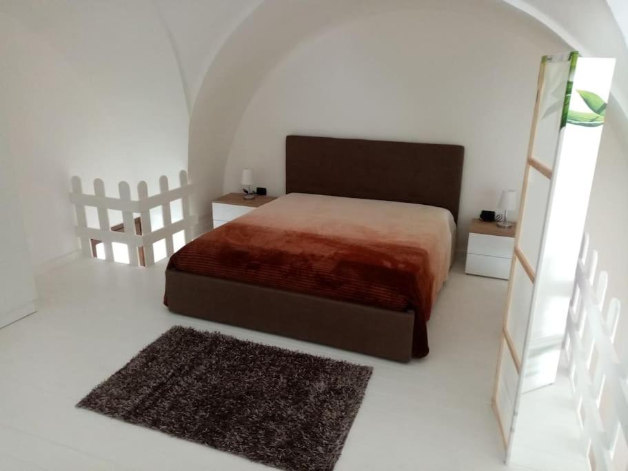 1 dormitorio con 1 cama en una habitación blanca en Paola's house, en Copertino