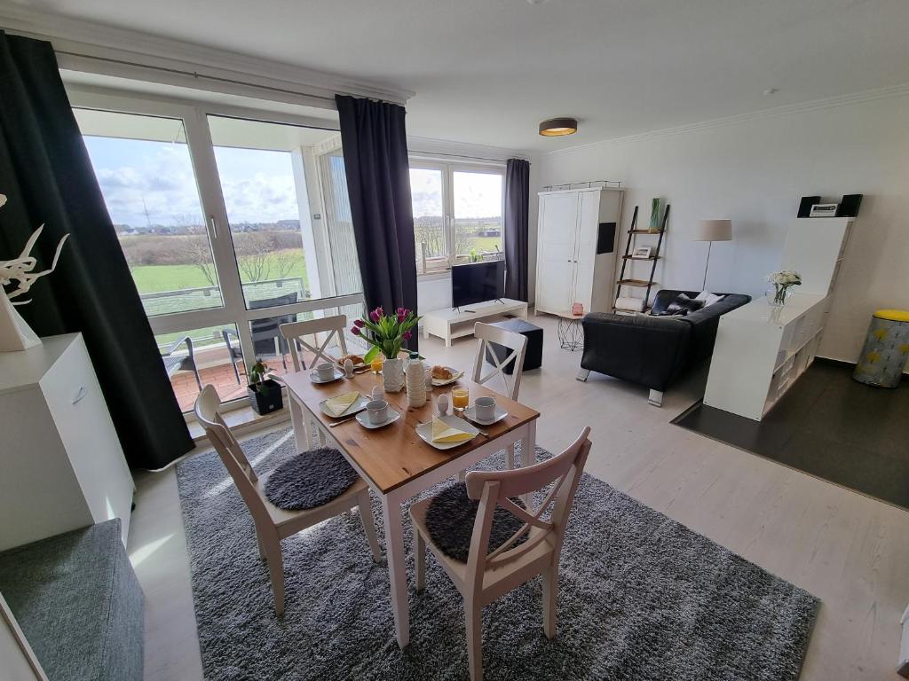 sala de estar con mesa y sillas en una habitación en Strand & Heide - Tolles Schwimmbad, en Cuxhaven