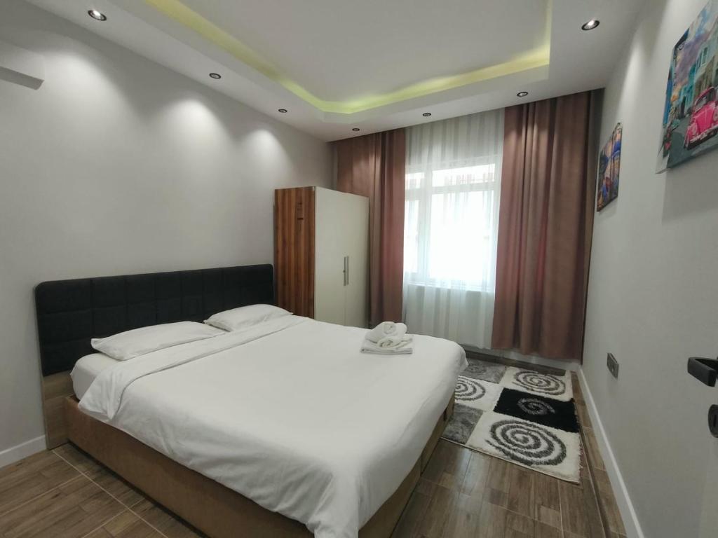 una camera da letto con un grande letto bianco e una finestra di Tekin Suit a Bandırma