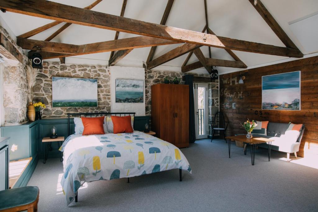 a bedroom with a bed and a stone wall at The Old Workshop in St Ives