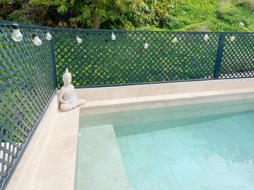 posąg kobiety siedzącej obok basenu w obiekcie Casa Almona SpainSunRentals 1131 w mieście Frigiliana