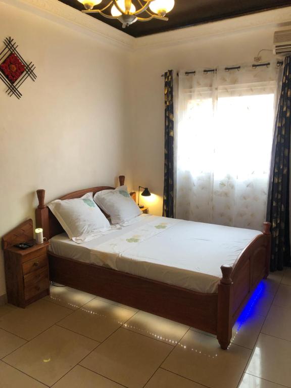 1 dormitorio con 1 cama grande y ventana en Grand Appartement à essos mobile, en Yaoundé