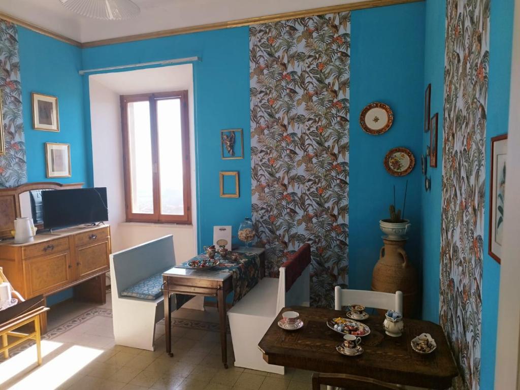 un soggiorno con pareti blu e tavolo in legno di B&B Leopardi a Montefiore dellʼAso