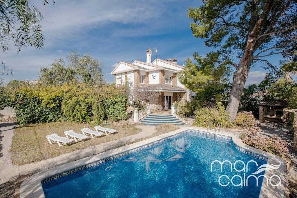 a house with a swimming pool in front of a house at Villa Elvira by MarCalma in Les tres Cales