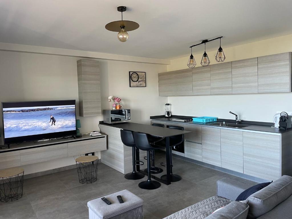 TV a/nebo společenská místnost v ubytování Charmant F2 à SkyNui, piscine de 25m et vue mer