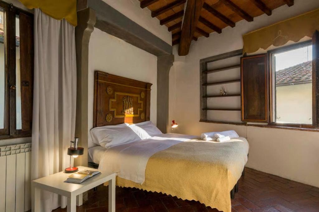 a bedroom with a large bed and a table at Residenza dei Medici Palace Niccolò in Florence