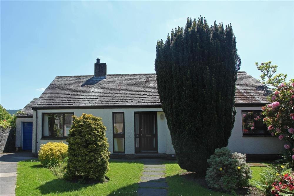 a white house with a large tree in front of it at Beck Yeat Cottage Coniston in Coniston