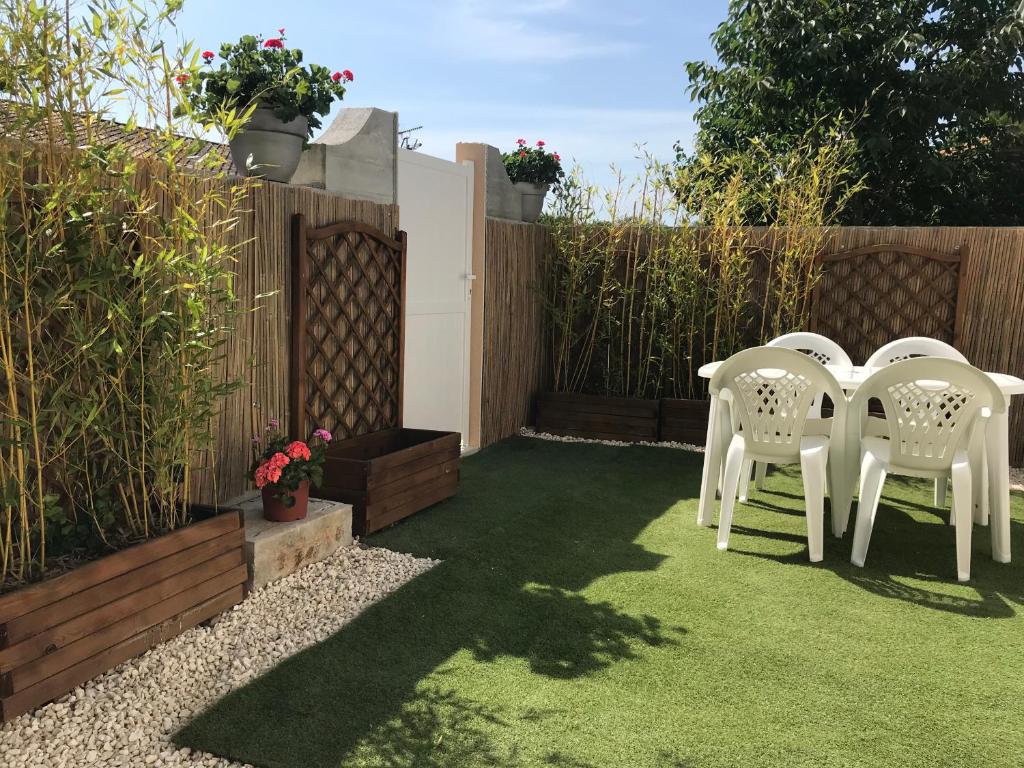 dwa białe krzesła siedzące na trawie w ogrodzie w obiekcie Studio 35m2 à 3 km de la gare d Angoulême avec draps et linge de maison fournis w mieście Le Gond-Pontouvre