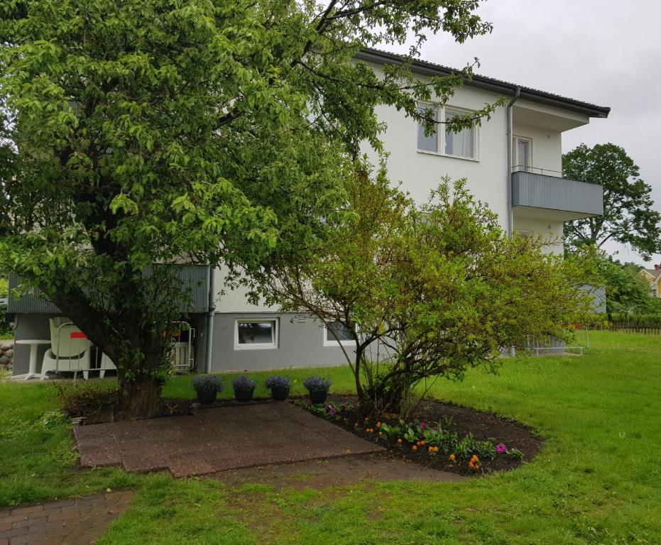 a house with a tree and flowers in front of it at Ekonomirum i Karlstad in Karlstad