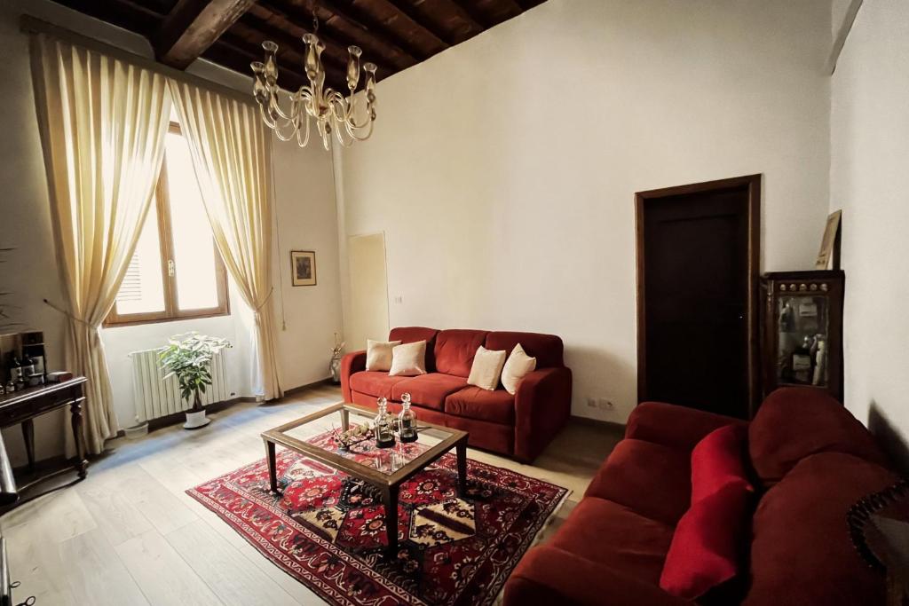 uma sala de estar com um sofá vermelho e uma mesa em Da Mario in Florence Guesthouse em Florença