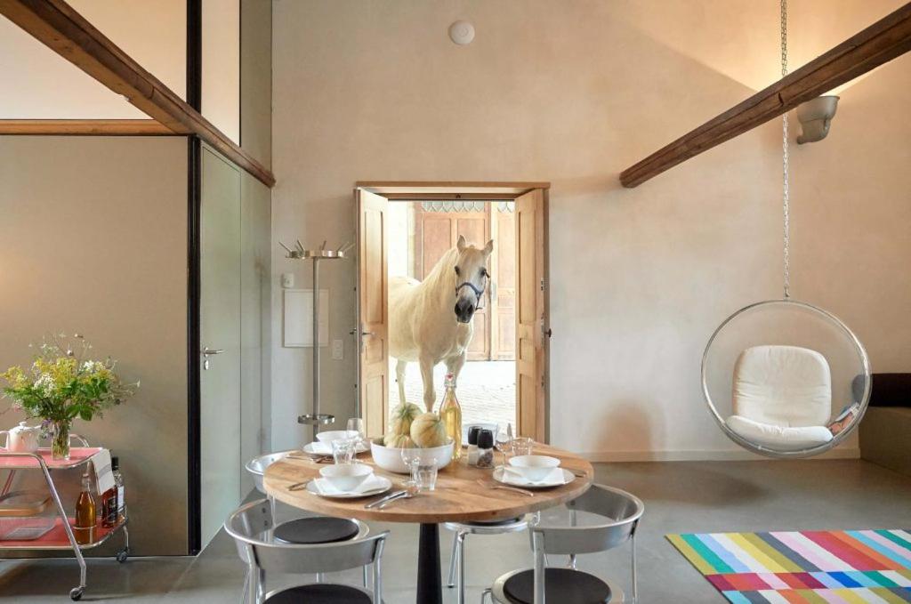 a room with a table with a horse standing in the window at Dépendance de Sibra in Lagarde