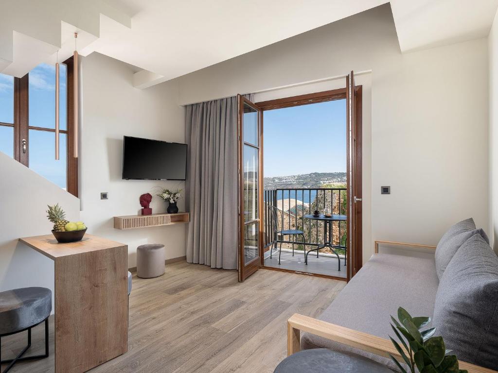 ein Wohnzimmer mit einem Sofa und einem Balkon in der Unterkunft Ethos Suites in Chania