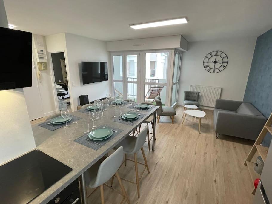 cocina y sala de estar con mesa grande con sillas en Urban flat au cœur de Lorient, en Lorient