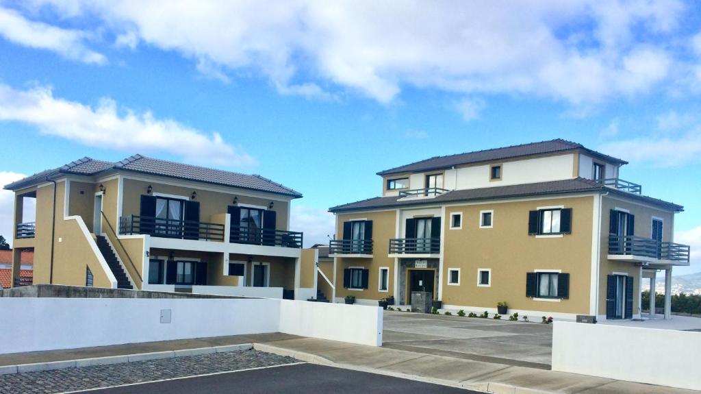 two buildings with balconies and a blue sky at Villa Da Madalena in Madalena