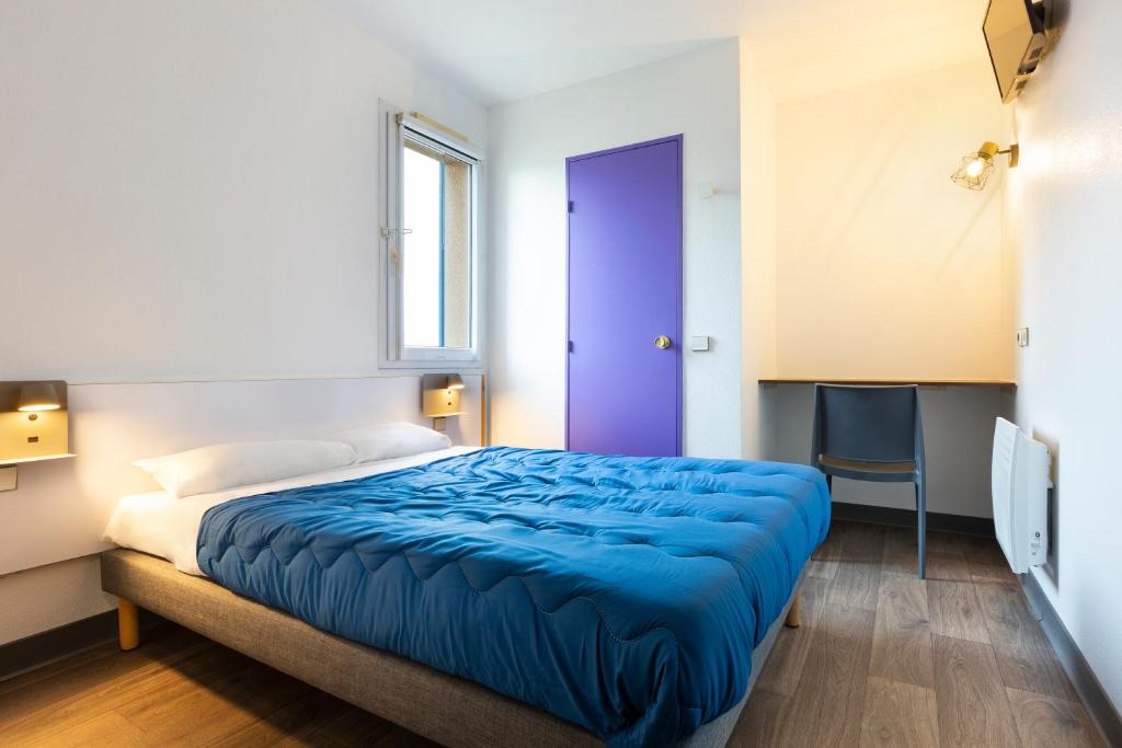 a bedroom with a bed with a blue blanket at Mister Bed Saran in Saran