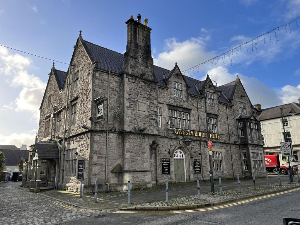 an old stone building on the corner of a street at The Bull Hotel in Llangefni