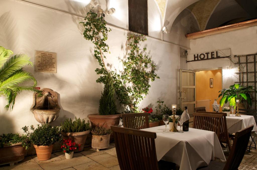a restaurant with two tables and potted plants at Hotel Schlicker in Munich