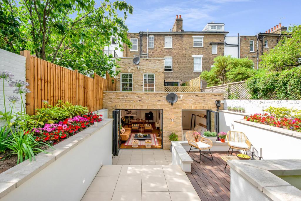 an outdoor patio with a garden with flowers at Be London - The De Beauvoir Residences in London