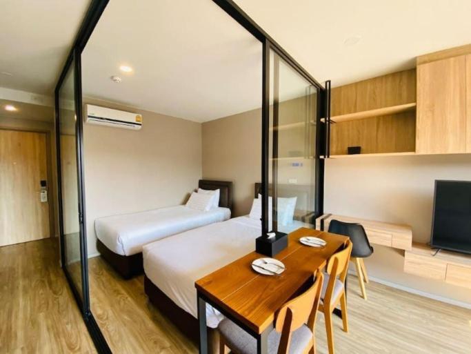 a hotel room with a bed and a table and a bed at Blossom condo in Yan Nawa