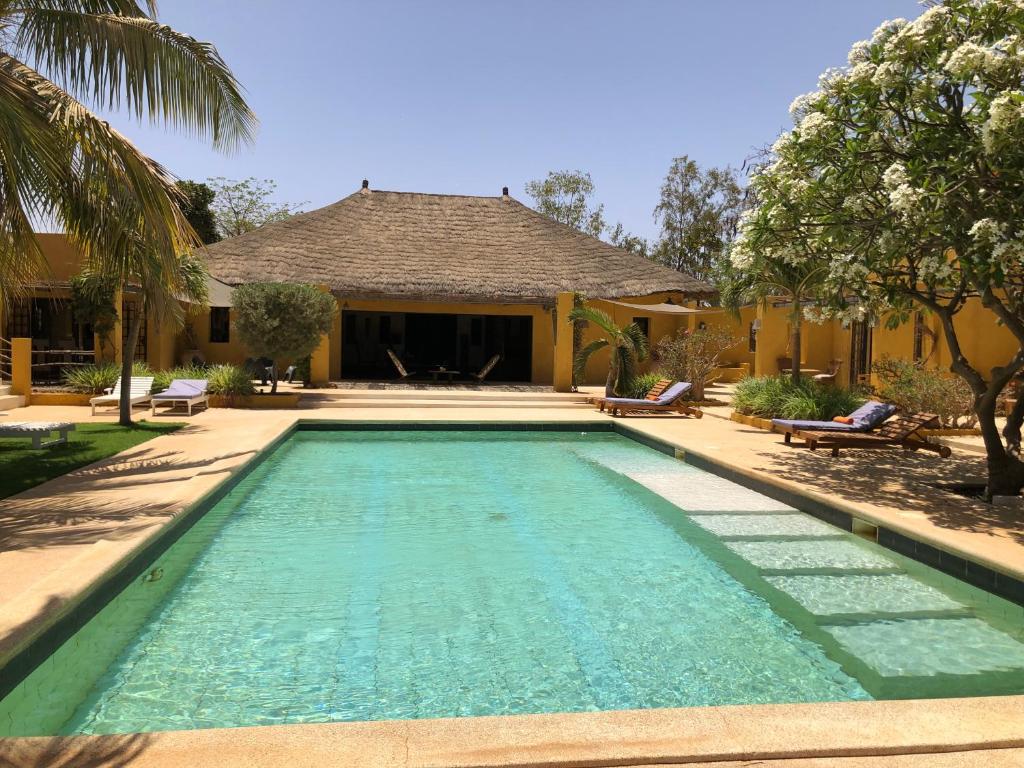 a swimming pool in front of a house at Toubana Lodge in Ngaparou