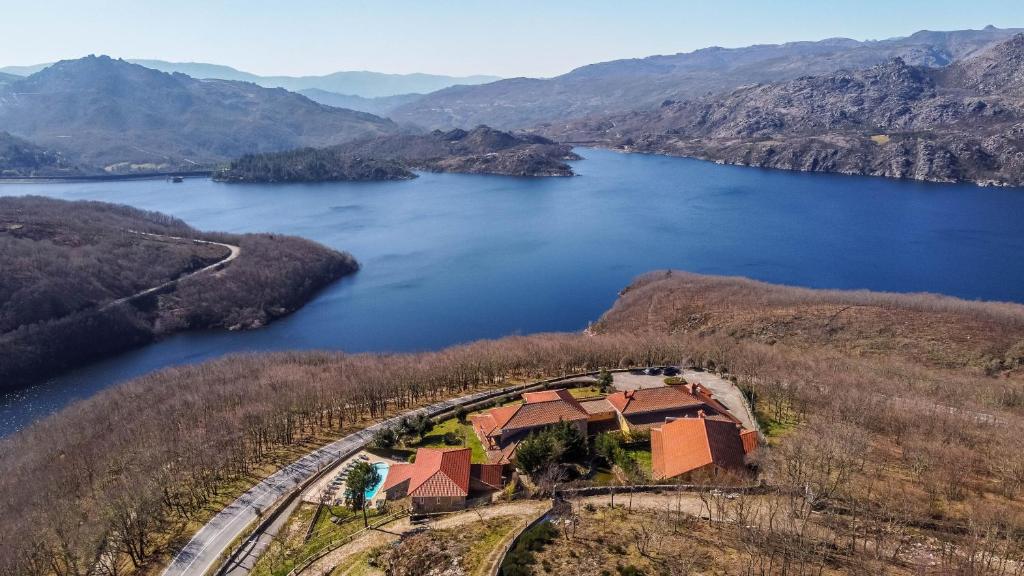 an aerial view of a house in the middle of a lake at Hotel Vista Bela do Gerês in Outeiro