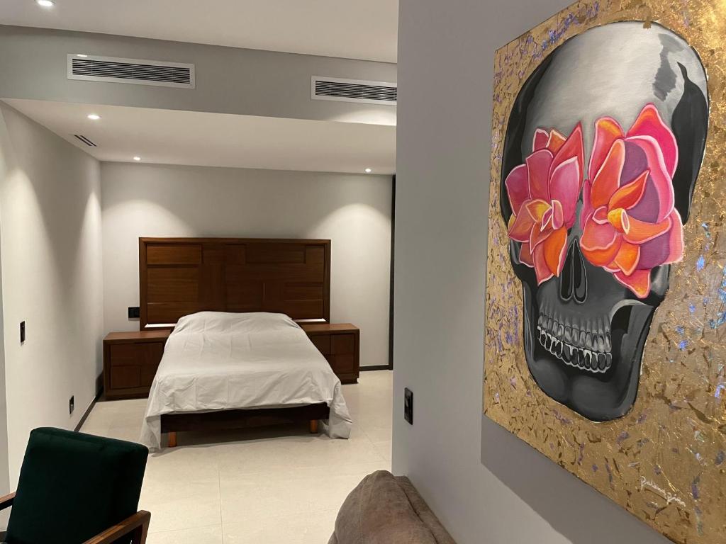 a bedroom with a skull and flowers painting on the wall at Depto moderno en torre lujosa in Guadalajara