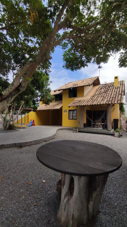 una mesa sentada en la parte superior de un tronco de árbol en Cabelera's House en Bombinhas