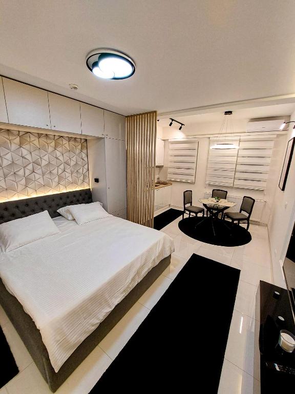 a bedroom with a large bed and a table at A'dors Apartments in Skopje