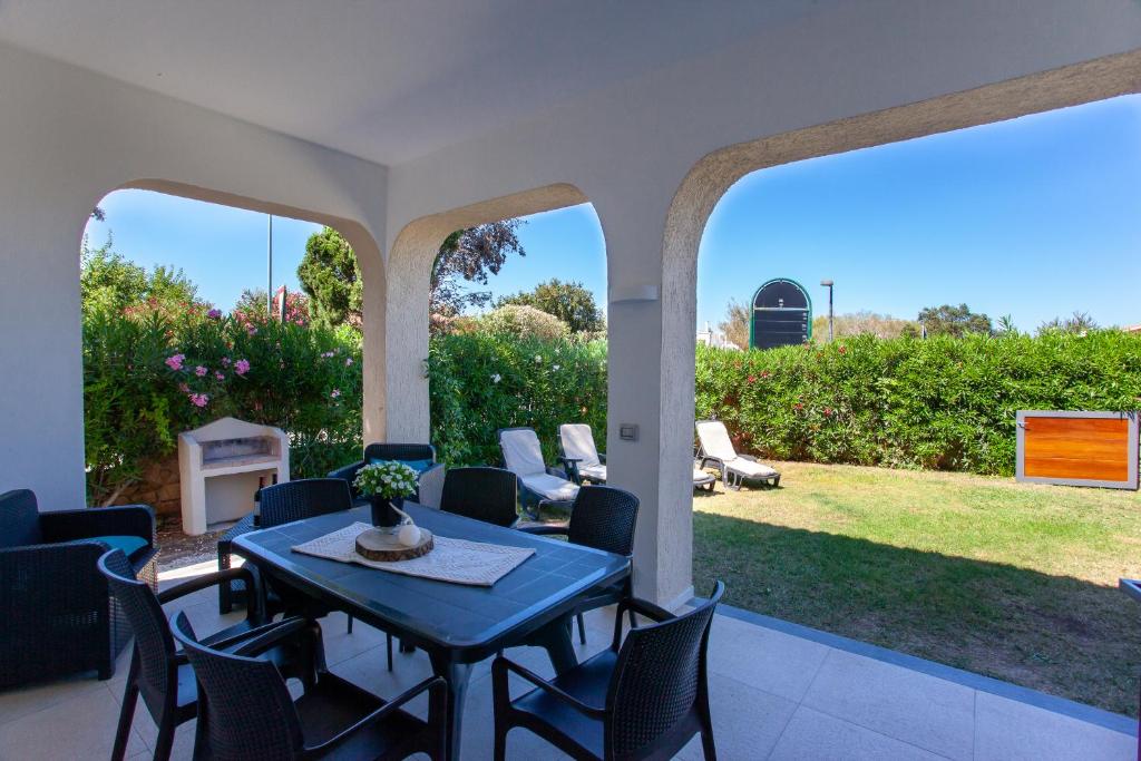 a patio with a table and chairs and a yard at Villetta La Conchiglia Man in San Teodoro
