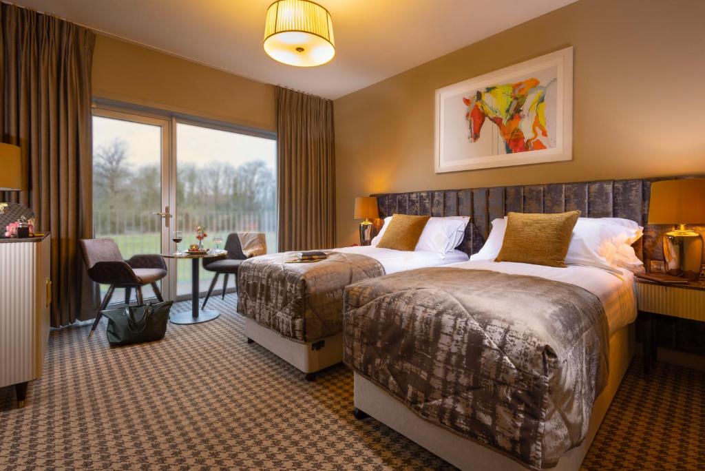 una habitación de hotel con dos camas y una mesa en The Club Hotel at Goffs, en Naas