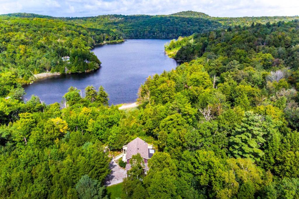 an aerial view of a house in the middle of a lake at Lakefront Otis Home with Stunning Views and Boats! in Otis