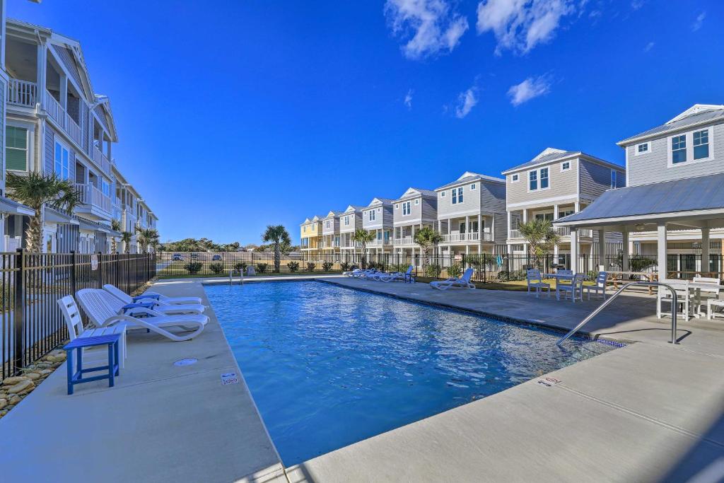 a swimming pool in a apartment complex with chairs and condos at Gorgeous Emerald Isle Getaway Walk to Beach! in Emerald Isle