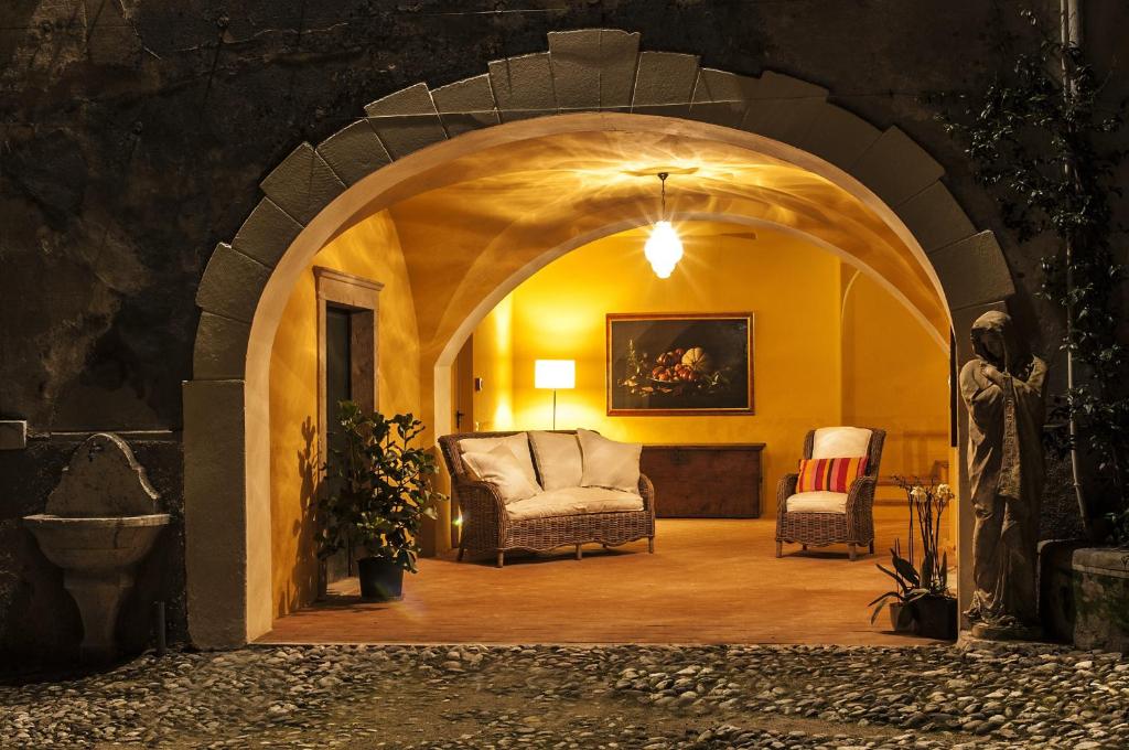 a living room with an archway with a couch and chairs at B&B Corte delle Muse in San Felice del Benaco