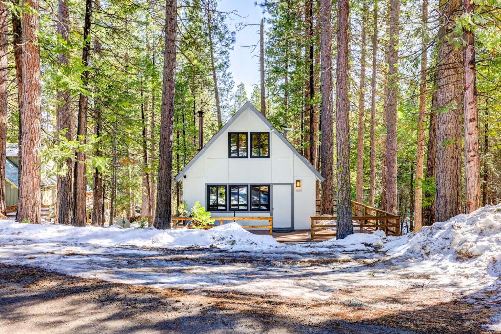 a small white house in the woods at Hike, Fish and Explore California Cabin with Deck! in Long Barn
