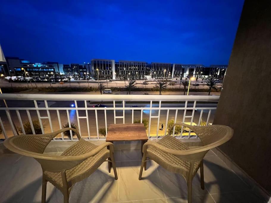 2 Stühle und ein Tisch auf dem Balkon in der Nacht in der Unterkunft Madinaty cheapest and luxury in Madinaty